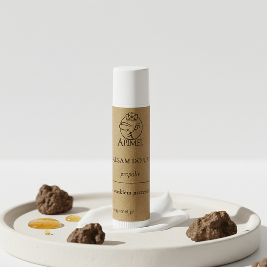 Balsam do ust propolisowy Apimel z woskiem pszczelim naturalna pielęgnacja na jasnym tle z propolisem i miodem